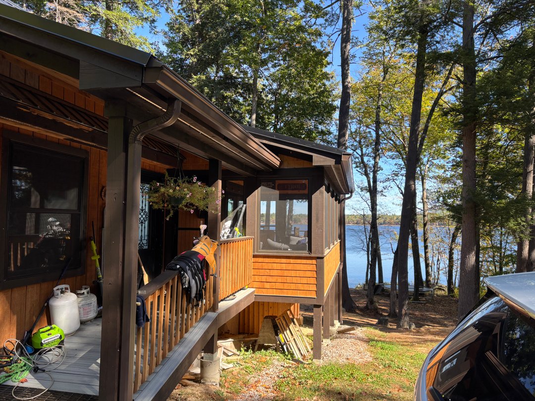 Brown aluminum gutters on a lakeside Maine cabin
